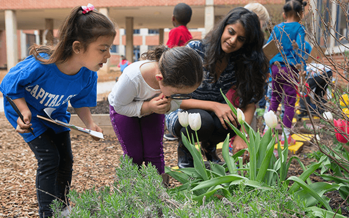 Membros da equipe interagindo com crianças em um jardim